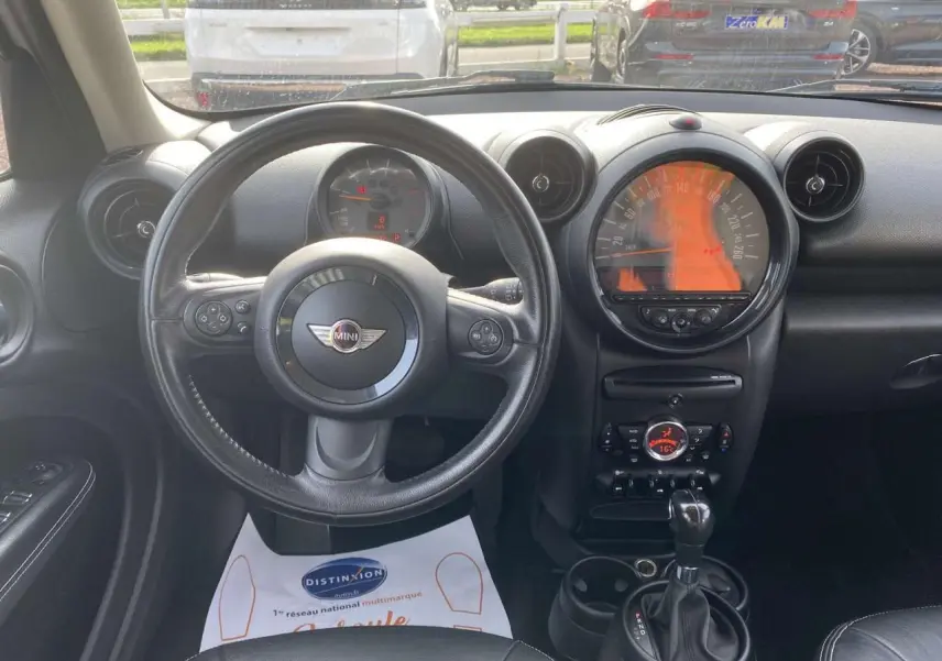 Vue intérieure du tableau de bord et volant noir de la MINI Countryman 2015 avec commandes intégrées et console centrale.
