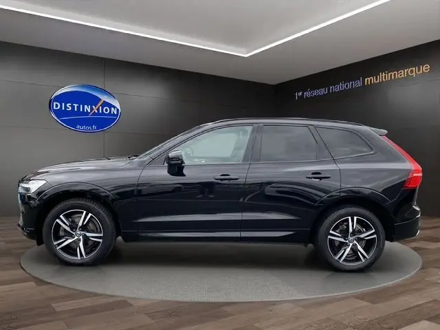 Profil côté gauche d'un Volvo XC60 noir 2021 R-Design avec toit panoramique et jantes alliage cinq branches.