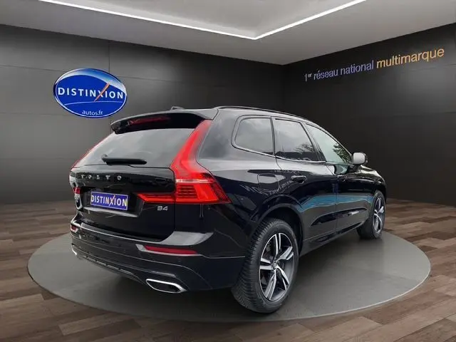Vue 3/4 arrière droite d'un Volvo XC60 noir avec feux arrière en L et double sortie d'échappement chromée.