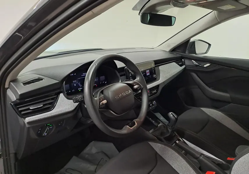 Intérieur avant droit du Skoda Kamiq gris graphite 2025, volant multifonction et tableau de bord digital.