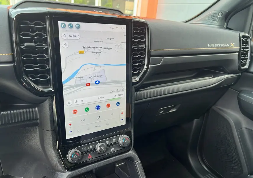 Vue intérieure du tableau de bord du Ford Ranger 2025 Wildtrak X avec écran tactile vertical et surpiqûres orange.