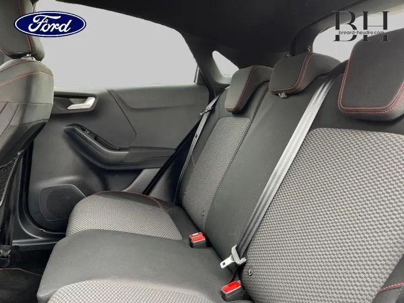 Vue latérale intérieure montrant la banquette arrière noire avec surpiqûres rouges du Ford Puma 1.5 EcoBlue 2021.