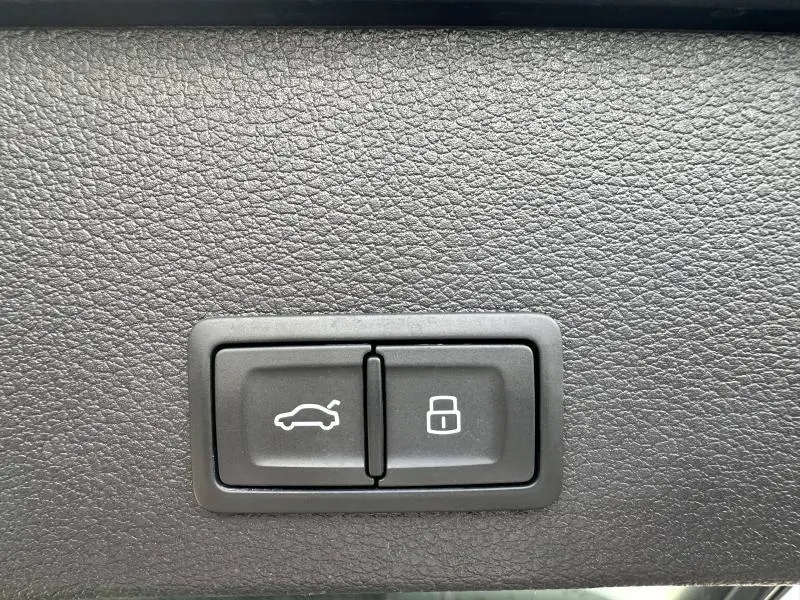 Boutons de commande pour ouverture du coffre et verrouillage, intégrés dans l'habitacle de l'Audi Q2 gris Daytona nacré 2024
