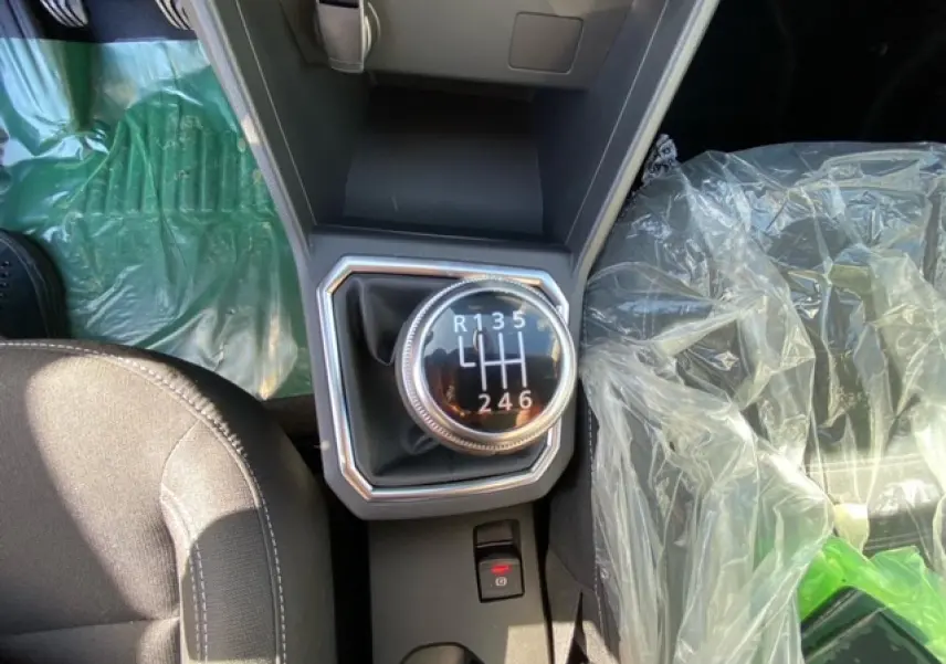 Gros plan sur le levier de vitesses manuel de la Dacia Logan gris 2022, entouré des sièges avant et console centrale.