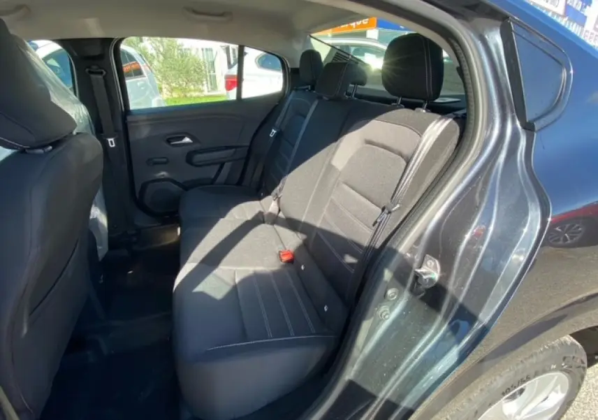 Vue intérieure arrière côté droit d'une Dacia Logan gris 2022, sièges arrière en tissu noir avec ceinture de sécurité.
