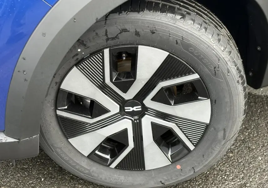 Gros plan sur la roue avant gauche d'une Dacia Sandero Stepway 2025 Bleu Iron avec jante 16 pouces Atara Dark.