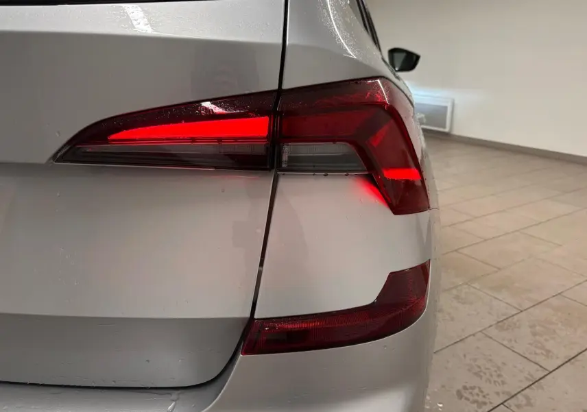 Gros plan sur le feu arrière droit allumé d’un Skoda Kamiq gris argent 2025 avec peinture métallisée.