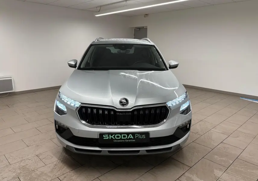 Vue avant frontale du Skoda Kamiq gris argent avec phares LED allumés et calandre noire brillante.