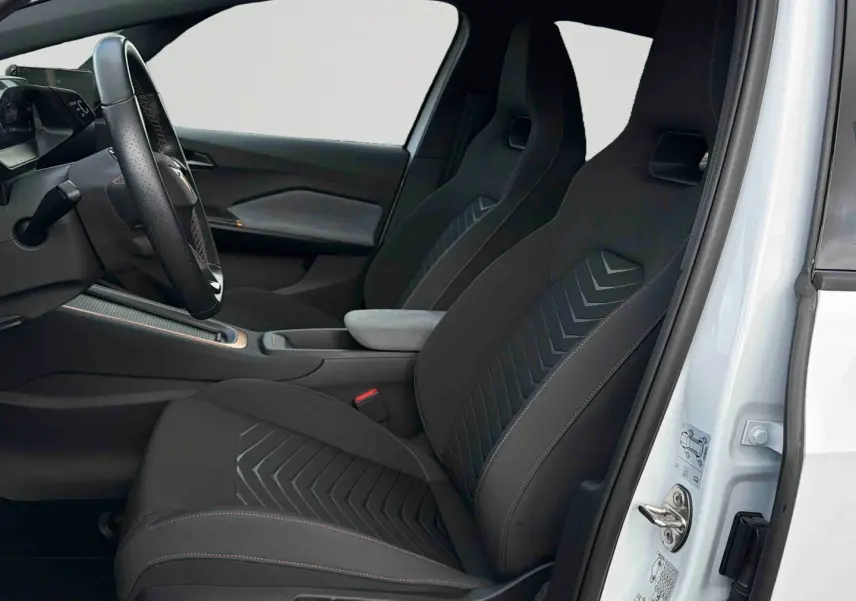 Vue intérieure côté conducteur de la CUPRA Born blanche 2024, sièges sport noirs avec surpiqûres et volant multifonction.