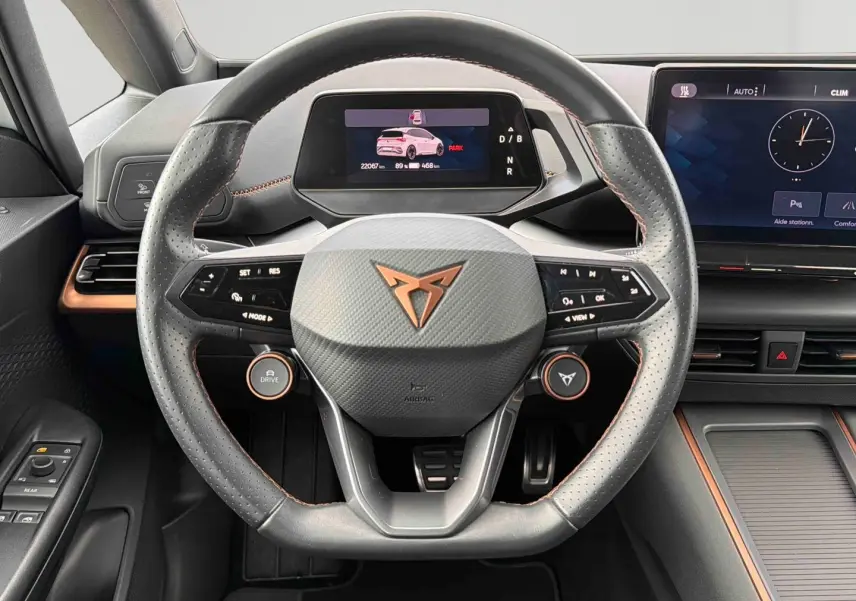 Vue rapprochée du volant multifonction noir et gris avec logo CUPRA cuivré du tableau de bord du CUPRA Born blanc électrique 2024.
