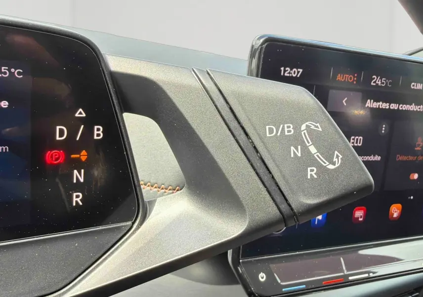 Détail du levier de vitesses électrique avec affichage digital, intérieur moderne du CUPRA Born blanc 2024.