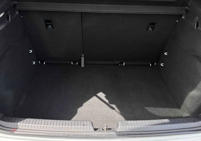 Coffre ouvert vu de face d'une CUPRA Born blanche 2024, montrant un espace de chargement vide et propre.