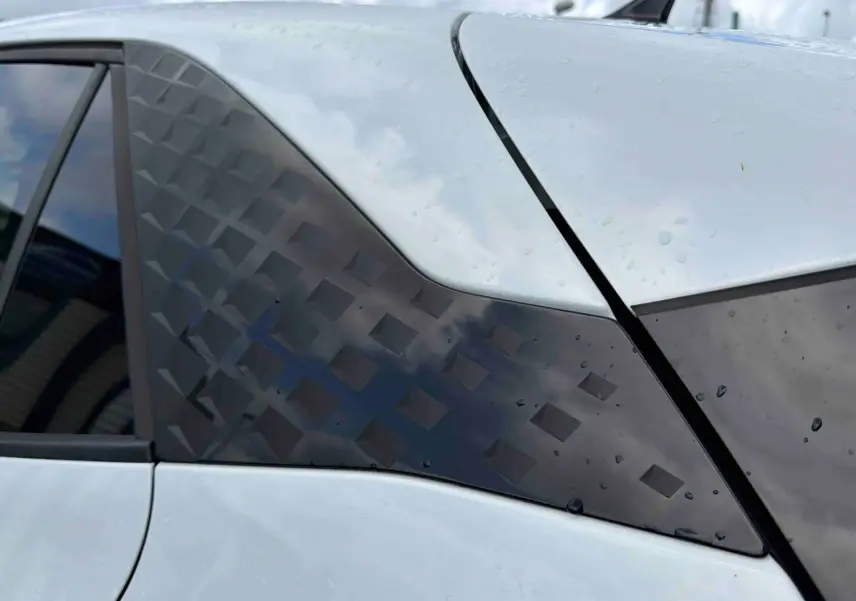 Détail du montant arrière droit blanc du CUPRA Born 2024 avec motif géométrique noir et vitre teintée.