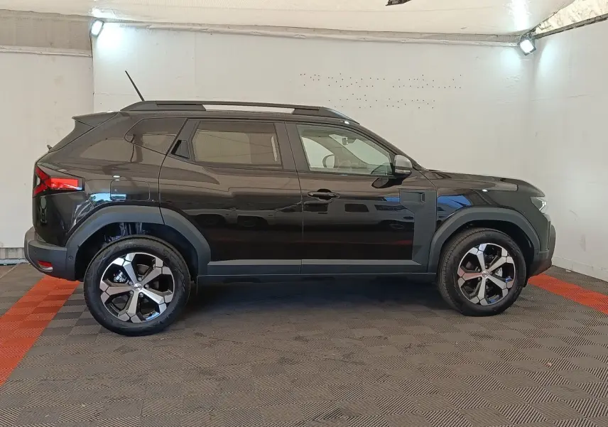 Vue de profil côté gauche du Dacia Duster Journey Hybrid 155 noir, avec jantes alliage et barres de toit noires.