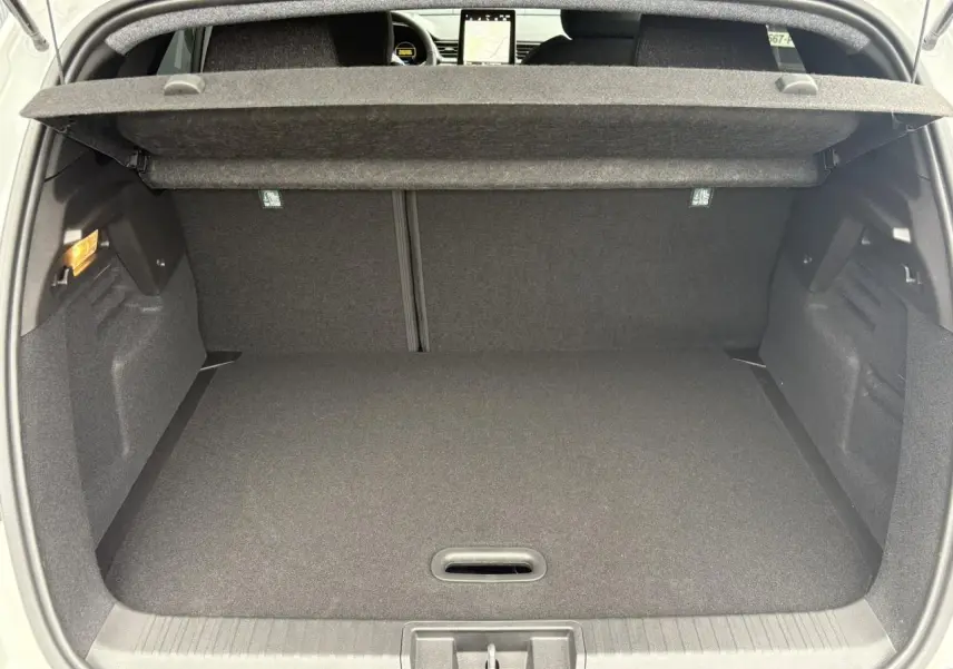 Coffre ouvert du Renault Captur blanc nacré, vue arrière montrant l'espace de rangement et la tablette de couverture.