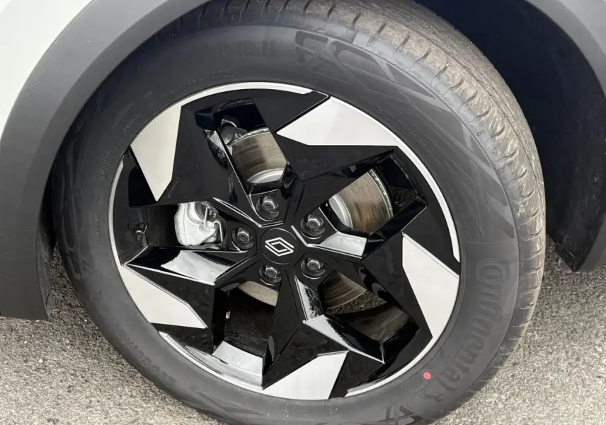 Gros plan sur la jante aluminium 18 pouces Black Hole noire et argentée du Renault Captur blanc nacré.