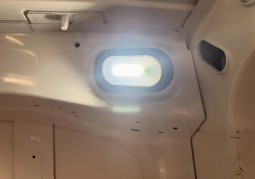 Éclairage intérieur blanc allumé dans la partie arrière du Citroën Berlingo blanc de 2019, vue en gros plan.