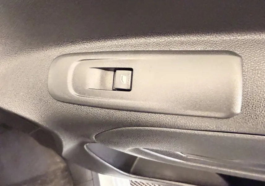 Gros plan sur le bouton de commande de la vitre électrique côté conducteur du Citroën Berlingo blanc de 2019.