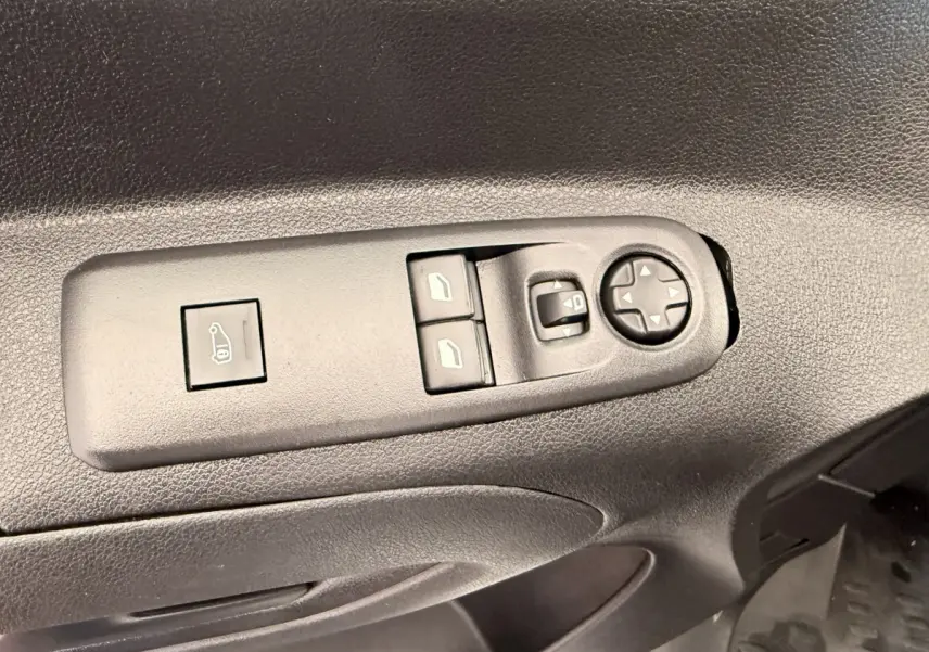 Détail des commandes de réglage des vitres et des rétroviseurs sur la porte côté conducteur d’un Citroën Berlingo blanc de 2019.