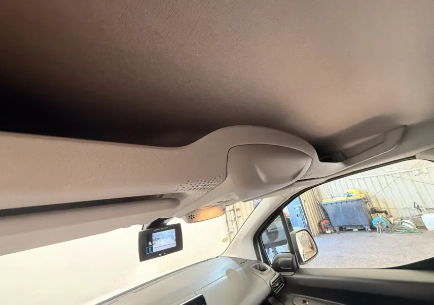 Vue intérieure côté passager du tableau de bord d'un Citroën Berlingo blanc 2019 avec écran de caméra de recul.