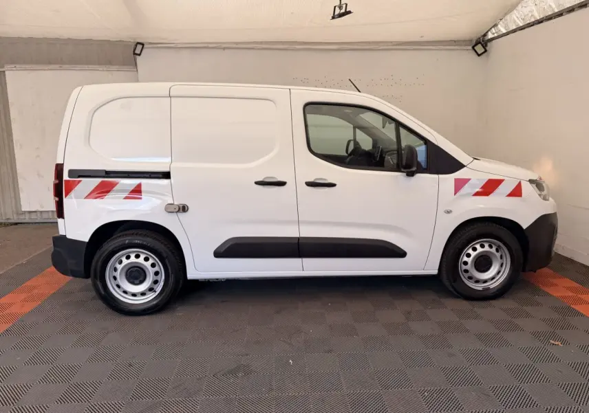 Vue de profil côté droit d'un Citroën Berlingo blanc 2019 avec bandes réfléchissantes rouges sur ailes avant et arrière.
