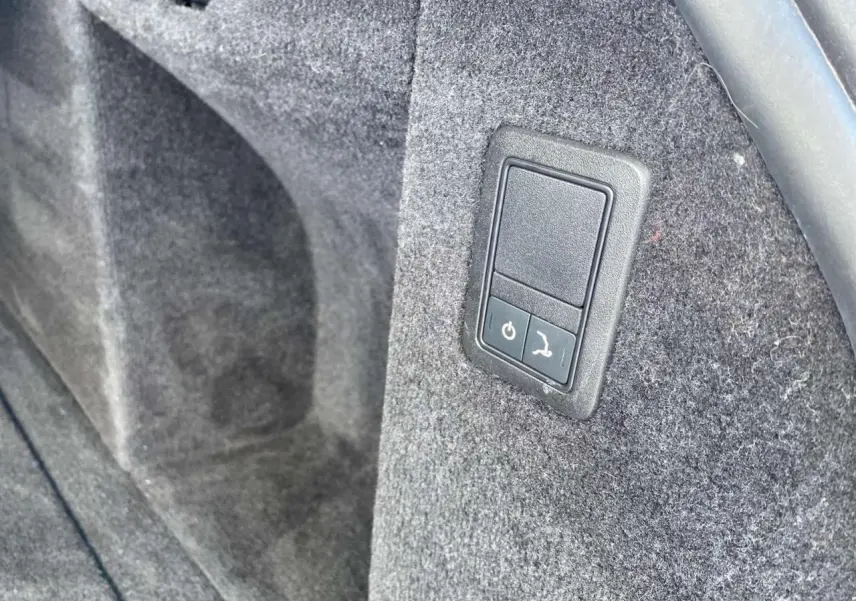 Bouton électrique de déploiement du crochet d'attelage dans le coffre du Range Rover Sport SVR noir 2016.