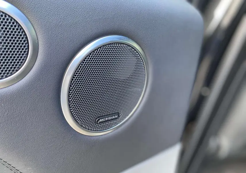 Gros plan sur l'enceinte Meridian intégrée à la porte intérieure du Range Rover Sport noir SVR 2016.