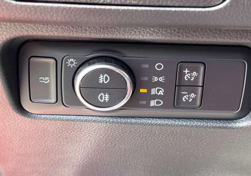 Gros plan sur les commandes d’éclairage du Ford Ranger Raptor 2025 en gris météore, avec bouton rotatif et réglages lumineux.