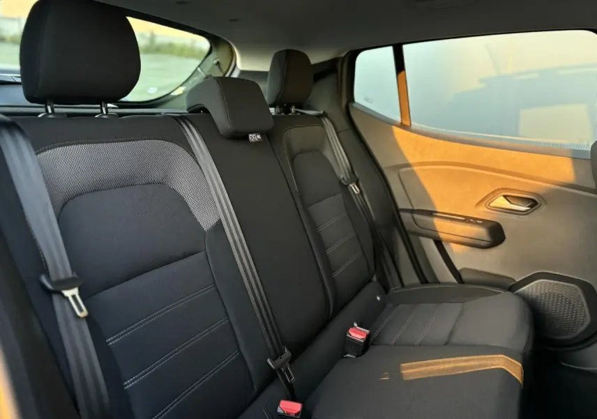 Vue latérale intérieure de la banquette arrière noire du Dacia Sandero Stepway 2025 avec ceintures et appuie-têtes.