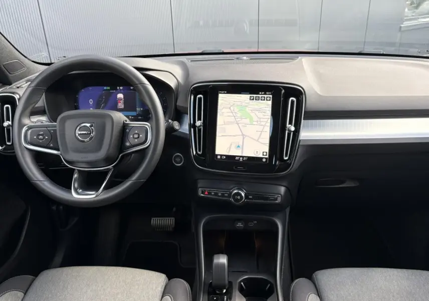 Intérieur du Volvo XC40 2024 vu de face, tableau de bord noir avec écran tactile central affichant la navigation.