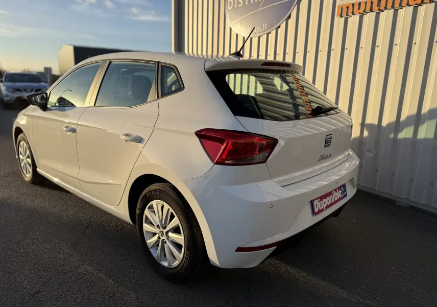 SEAT Ibiza 1.0 MPI blanche vue en 3/4 arrière droit, avec feux arrière rouges et jantes alliage visibles.