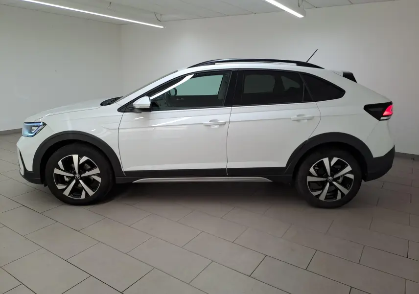 Vue de profil côté gauche d’un Volkswagen Taigo blanc pur 2024 avec jantes alliage 17 pouces et projecteurs antibrouillard avant.