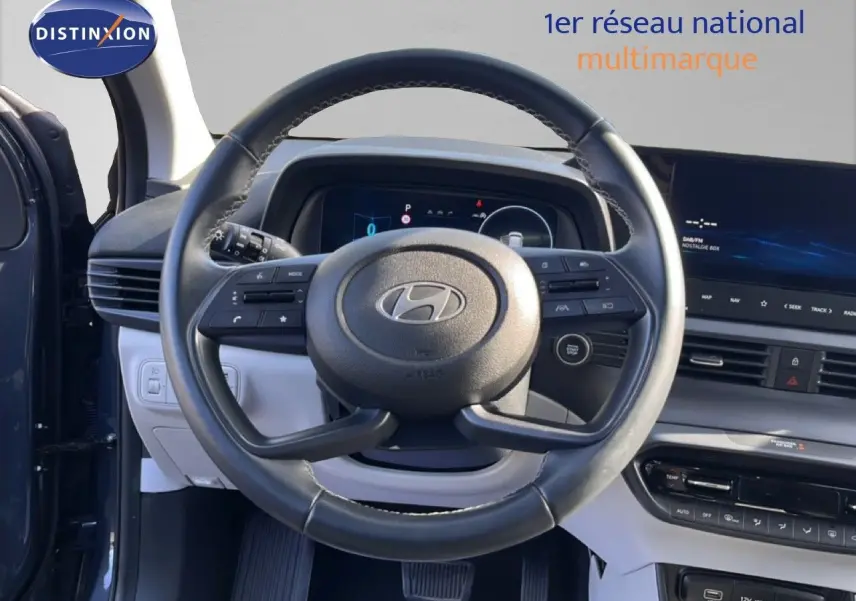 Vue centrée sur le volant cuir de la Hyundai i20 2025 gris Aurora, avec tableau de bord numérique et écran tactile.