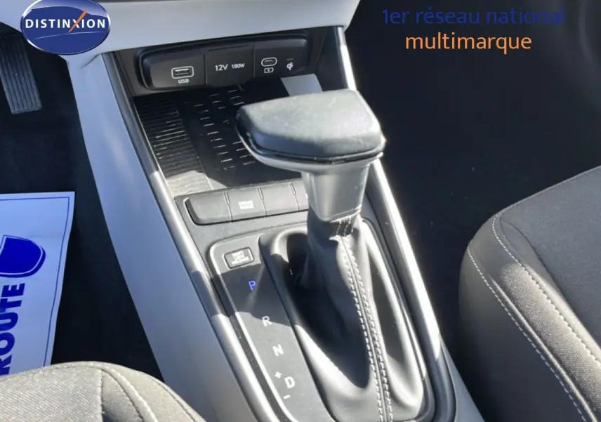 Gros plan sur la console centrale de la Hyundai i20 2025 gris aurora, mettant en valeur le levier de vitesses automatique et les ports USB.