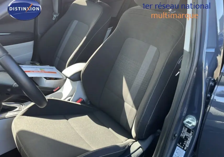 Vue intérieure côté conducteur de la Hyundai i20 2025 gris Aurora, mettant en valeur les sièges tissu noir et console centrale.