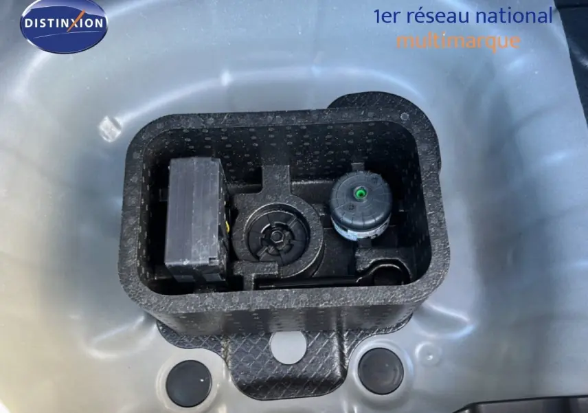 Vue en plongée sur le compartiment de rangement gris Aurora métal d'une Hyundai i20 2025, montrant les outils intégrés.