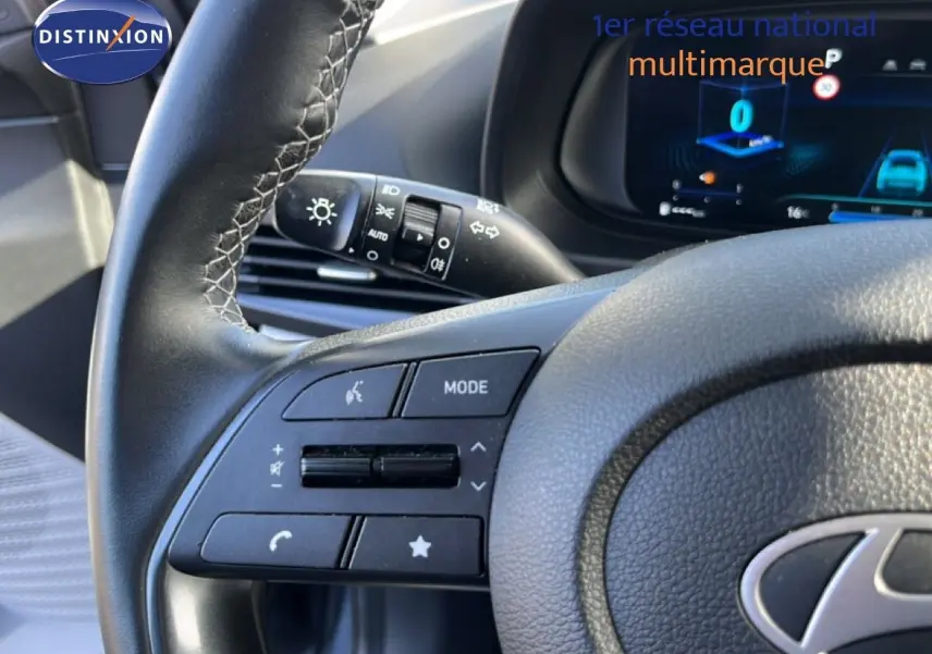 Gros plan sur le volant cuir gris avec commandes multifonctions de la Hyundai i20 2025 en intérieur.