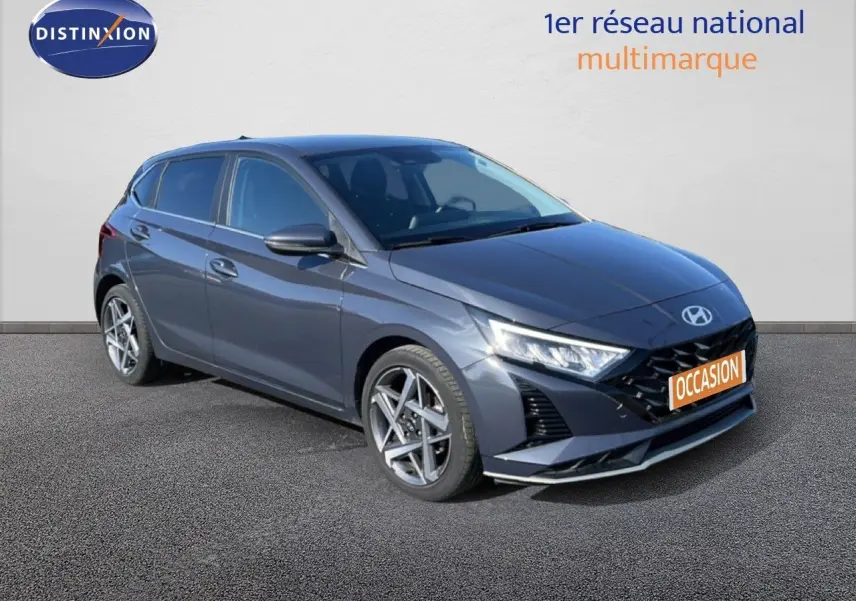 Hyundai i20 gris Aurora métal en 3/4 avant droit, avec jantes alliage et calandre noire distinctive.