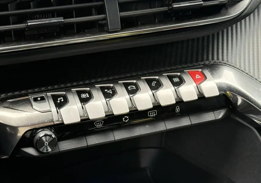 Gros plan sur la rangée de boutons argentés et noirs du tableau de bord du Peugeot 3008 Plug-in Hybrid gris Artense.