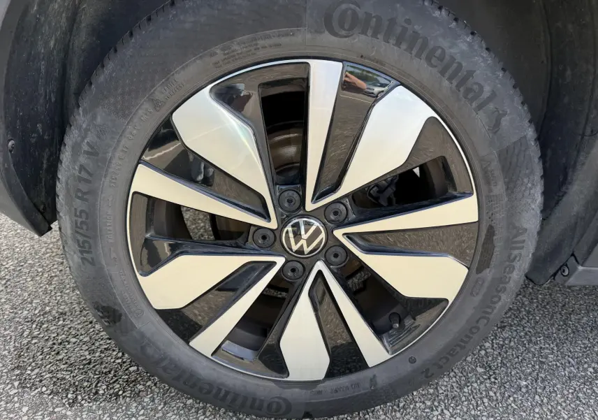 Gros plan sur la jante alliage bicolore d’un Volkswagen T-Roc gris, avec pneu Continental visible.