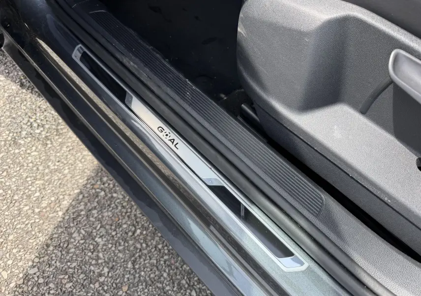 Gros plan sur la plaque de seuil de porte côté gauche du Volkswagen T-Roc gris, avec intérieur en plastique noir.