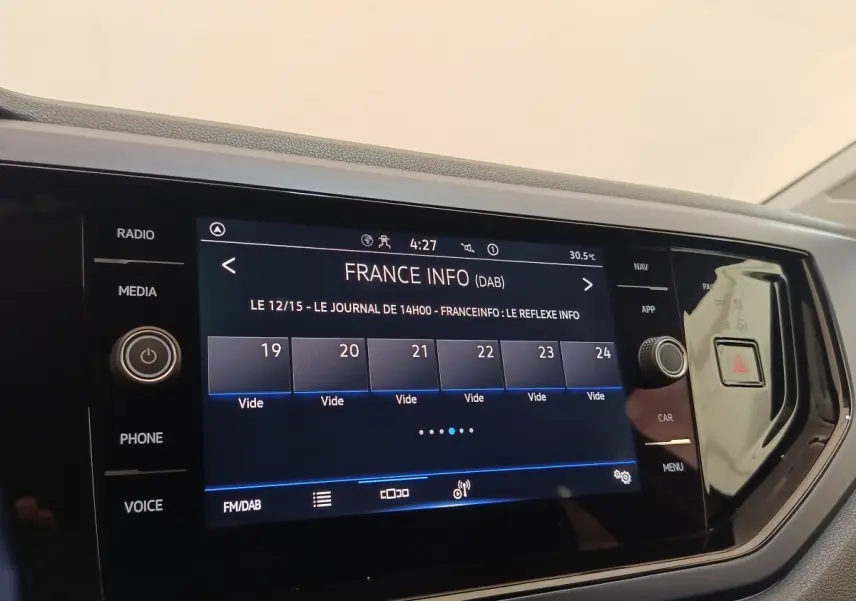 Écran tactile central de la Volkswagen Polo 1.0 TSI 95 United, affichage radio France Info, tableau de bord noir.