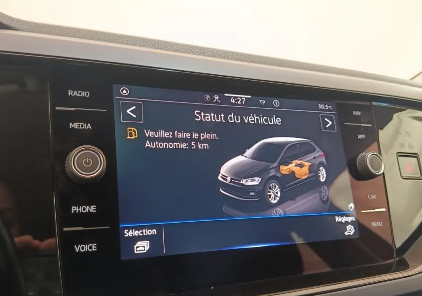 Écran tactile intérieur affichant le statut d'une Volkswagen Polo 1.0 TSI avec message d'autonomie faible.