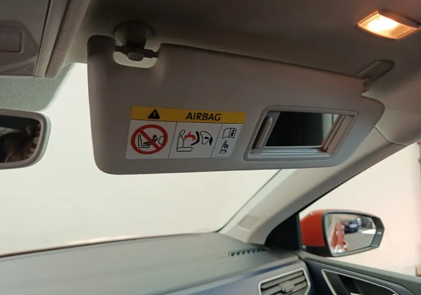 Intérieur Volkswagen Polo orange 2020, vue côté passager avec pare-soleil déplié et miroir intégré.