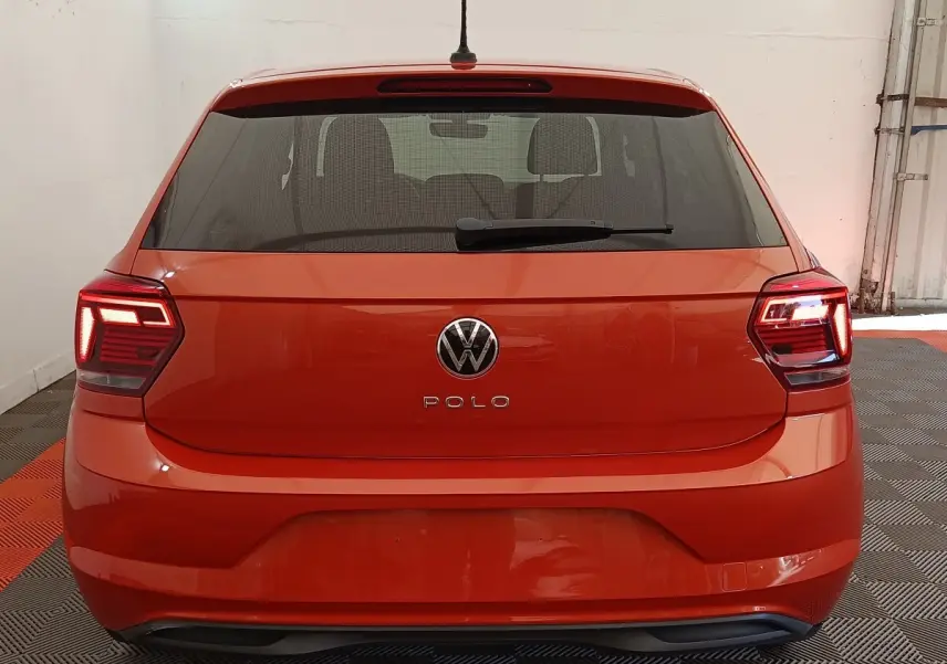 Vue arrière d'une Volkswagen Polo orange 2020 avec feux LED allumés dans un garage.