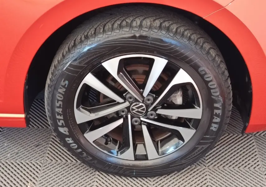 Gros plan sur la roue avant droite d'une Volkswagen Polo orange avec jante alliage bicolore et pneu Goodyear.