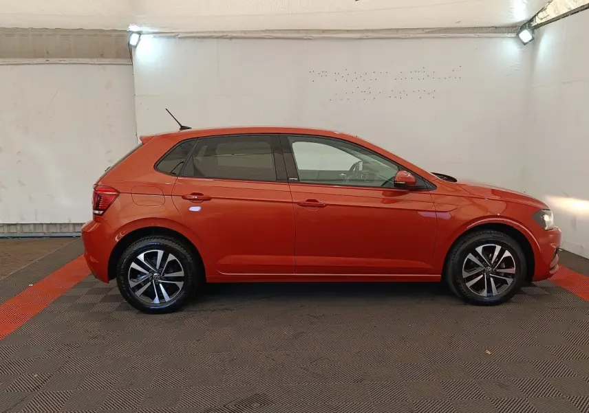 Profil droit d'une Volkswagen Polo 1.0 TSI 95 United orange, avec jantes alliage et vitres teintées, en intérieur neutre.