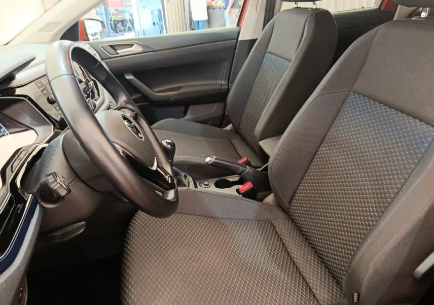 Vue intérieure côté conducteur de la Volkswagen Polo 1.0 TSI 95 United avec sièges tissu gris et volant cuir multifonctions.