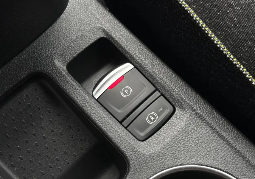 Gros plan sur la console centrale noire du Renault Captur 2026, montrant les boutons du frein à main et auto-hold.
