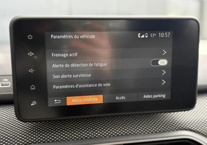 Écran tactile central du tableau de bord de la Dacia Sandero Stepway gris Schiste, affichant les paramètres d'aide à la conduite.